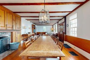 a large dining room with a long table and chairs at All-suite Boothbay Harbor home with deck, ocean views, and fireplaces in Boothbay Harbor +23 photos