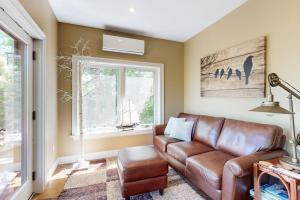 a living room with a brown leather couch and a window at Dog-friendly home with high-speed WiFi, washer/dryer, & private dock in Cundys Harbor