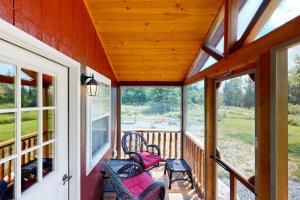 a screened porch with two chairs and windows at Cozy Cabin with Ocean and Mountain Views, Free Internet in Sullivan