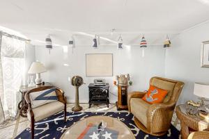 a living room with a couch and chairs and flags at Multi-unit with oar & boat house with private dock & kayaks in Boothbay Harbor