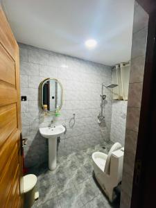 a bathroom with a sink and a toilet and a mirror at Appartements Rebero Hills in Kigali +10 photos