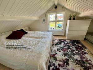 a bedroom with a white bed with a floral rug at Bagarestigen bargel punkt s e in Lysekil