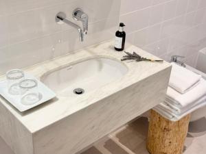a bathroom with a sink and a bottle of wine at Grota Lodging in Leiria