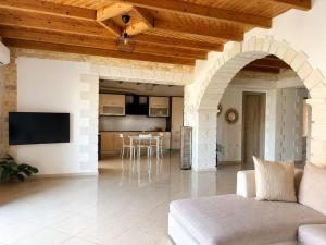 a living room with a couch and a kitchen at Cretan Nature Stone Apartment in Ayiás Filakaí