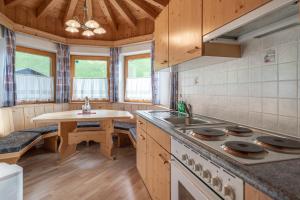 a kitchen with a stove and a sink and a table at Replers Hotel garni & Appartements in Prägraten