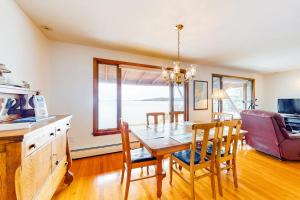 a dining room with a table and chairs and a couch at Waterfront home with beautiful bay views - near shops & dining in Owls Head +22 photos