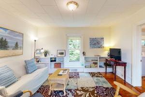 a living room with a white couch and a table at Cozy apartment with harbor view - full kitchen & washer/dryer - walk to water in Rockport
