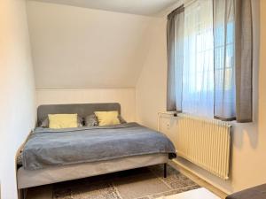 a small bedroom with a bed and a window at Cozy Family Retreat in a Quiet Village in Křešín