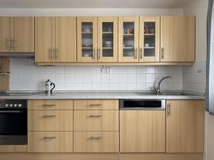 a kitchen with wooden cabinets and a sink at Cozy Family Retreat in a Quiet Village in Křešín