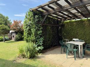 a patio with a table and chairs under a pergola at Cozy Family Retreat in a Quiet Village in Křešín
