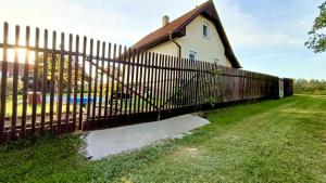 a fence in front of a house at Cozy Family Retreat in a Quiet Village in Křešín +11 photos