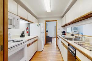a kitchen with a white refrigerator and a sink at Townhome w/ Bonus Loft, High-Speed WiFi, Partial AC & Full Kitchen in Bar Harbor +13 photos