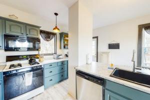 a kitchen with blue cabinets and a sink at Newly Renovated Haven w/ Deck, Walk to Shops, Dining & Marina, Pet friendly in Boothbay Harbor