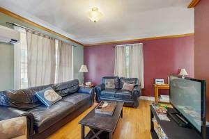 a living room with a couch and a flat screen tv at Dog-Friendly House with WiFi and Deck - Near the Water, Eateries, and Shopping in Bar Harbor