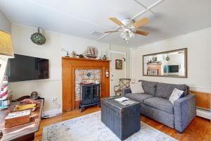 a living room with a couch and a fireplace at Historic Boothbay Harbor cottage with antique decor, washer/dryer & deck in Boothbay Harbor