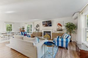 a living room with a couch and chairs and a fireplace at Newly Renovated Charming House with Cozy Fireplace & Outdoor Entertainment Areas in Rockport