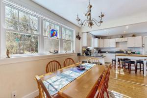 a kitchen and dining room with a table and chairs at Coastal bungalow with large yard, beautiful kitchen, & great location in Boothbay Harbor