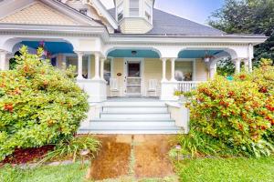 a yellow house with a porch and stairs at Dog-friendly historical home with recent updates, porch & prime in-town location in Rockland