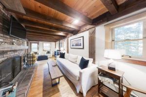 a living room with a white couch and a fireplace at Appalachee Pond Waterfront Cottage | Decks, Sunroom, Dock with Kayaks & Canoe in Boothbay Harbor +40 photos