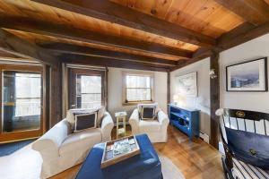 a living room with two couches and a table at Appalachee Pond Waterfront Cottage | Decks, Sunroom, Dock with Kayaks & Canoe in Boothbay Harbor