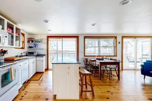 a kitchen with a table and a dining room at Dog-friendly river-view home with wood stove, deck, patio, dock, beach, grill in Boothbay +19 photos