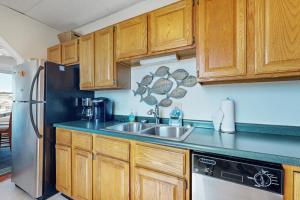 a kitchen with wooden cabinets and a stainless steel refrigerator at Admiral's Quarters in Boothbay Harbor +15 photos