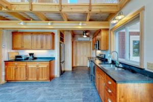 eine große Küche mit Holzschränken und einer Spüle in der Unterkunft Bayfront home with gorgeous water views, dock, outdoor patio, fireplace in Bowdoinham