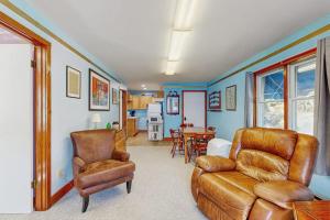 a living room with a couch and a chair at Charming, single-level getaway with a full kitchen, fast WiFi, & grassy yard in Boothbay