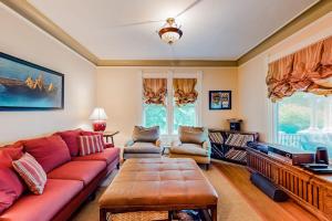a living room with a red couch and a television at Dog-friendly historical home with recent updates, porch & prime in-town location in Rockland