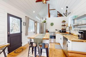 a kitchen with white walls and a black door at Brand-new dog-friendly home near Hancock Pond with firepit, grill, streaming, AC in Bucksport +11 photos