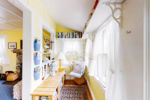 a room with yellow walls and a table and a window at Dog-friendly Fisher Hill home with patio and wood stove - walk to the harbor in Boothbay Harbor +19 photos