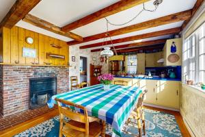 a kitchen and dining room with a table and a fireplace at Charming Seaside Cottage with a Gas Fireplace, Spacious Patio, and Nearby Hiking in Hancock +13 photos