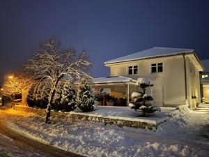 a house covered in snow at night at Secret Garden Spa House - Pool & Sauna in Großenlüder