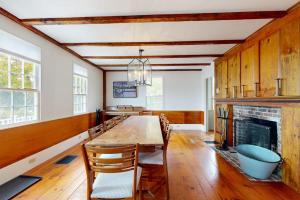 a dining room with a table and a fireplace at All-suite Boothbay Harbor home with deck, ocean views, and fireplaces in Boothbay Harbor