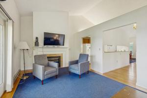 a living room with two chairs and a fireplace at Family & Dog-Friendly Townhouse w/Back Porch, Views, Partial AC in Bar Harbor