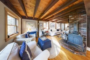a living room with a fireplace and a brick wall at Appalachee Pond Waterfront Cottage | Decks, Sunroom, Dock with Kayaks & Canoe in Boothbay Harbor