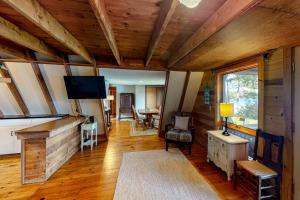 a living room with a flat screen tv in a cabin at Waterfront A-frame on George's Pond with views, private dock, beach, kayaks, SUP in Franklin