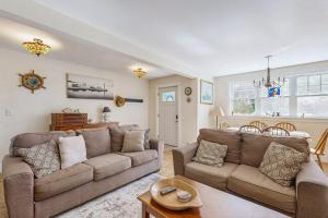 a living room with a couch and a table at Coastal bungalow with large yard, beautiful kitchen, & great location in Boothbay Harbor