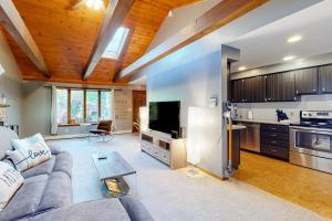 a living room with a couch and a kitchen at Tree-lined home with screened porch & perfect Midcoast location in Damariscotta