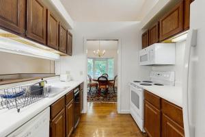 a kitchen with wooden cabinets and white appliances at Bay View Dog-Friendly Townhouse w/Porch, Gas Grill, Washer/Dryer, Partial A/C in Bar Harbor +11 photos