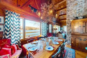a dining room with a table and a large window at Riverfront retreat with a furnished deck, washer/dryer & fast WiFi in Boothbay