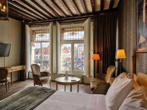 a hotel room with a bed and a table and chairs at Grand Hotel en Résidence De Draak in Bergen op Zoom +52 photos