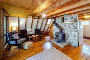 a living room with a stone fireplace in a house at Waterfront A-frame on George's Pond with views, private dock, beach, kayaks, SUP in Franklin
