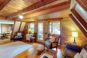 a living room with a couch and chairs in a cabin at Waterfront A-frame on George's Pond with views, private dock, beach, kayaks, SUP in Franklin