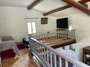 a living room with a staircase with a flat screen tv at Maison des lavandes in Apt
