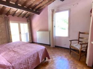 a bedroom with a bed and a chair and a window at Maison des lavandes in Apt +8 photos