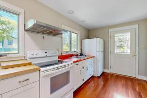 a kitchen with white appliances and a white refrigerator at Ocean Point Colony Home w/ Sunroom & Sweeping Ocean Views, Dog-friendly in East Boothbay
