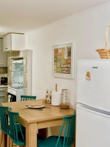 a kitchen with a wooden table and a refrigerator at Mitso's Talo in Samos