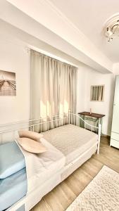 a white bedroom with a large bed and a window at Mitso's Talo in Samos