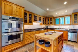 a kitchen with wooden cabinets and stainless steel appliances at Delightful oceanfront home with amazing views, wrap-around deck & two fireplaces in Wiscasset +28 photos